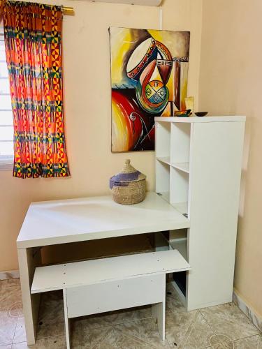 a white dresser in a room with a painting at Fadidi House in Dakar