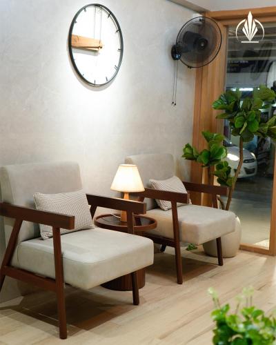 a room with two chairs and a clock on the wall at SIVANTA by BOMBAY GROUP OF HOTELS NAGPUR in Nagpur
