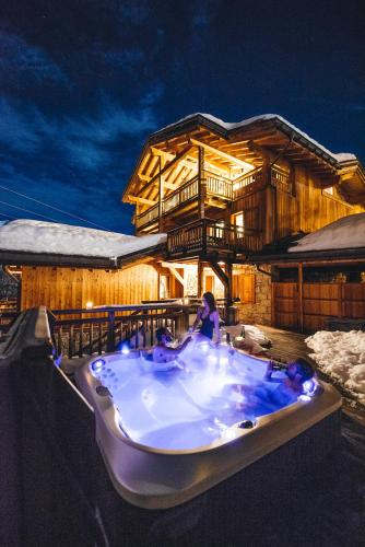 une baignoire jacuzzi en face d'un bâtiment dans l'établissement Joubarbe Violette by Lodji, à Saint-Martin-de-Belleville