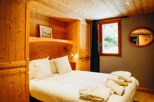 une chambre avec un lit dans une cabane en bois dans l'établissement Joubarbe Violette by Lodji, à Saint-Martin-de-Belleville