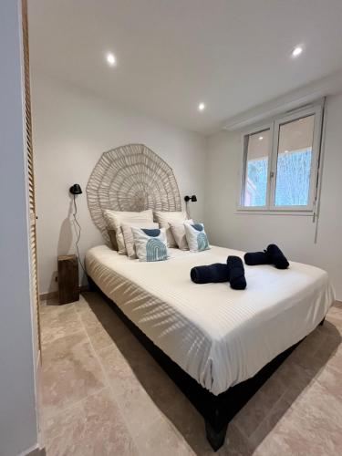 une chambre avec un grand lit avec des draps et des oreillers blancs dans l'établissement Appartement Soleil, à Cavalaire-sur-Mer