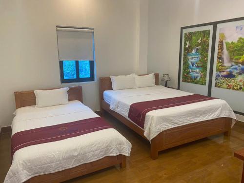 a bedroom with two beds and a painting on the wall at Luxury Airport Hotel - Convenient & Friendly in Hanoi