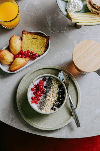 a table with a bowl of cereal and a plate of bread at Sangha Toulouse in Toulouse