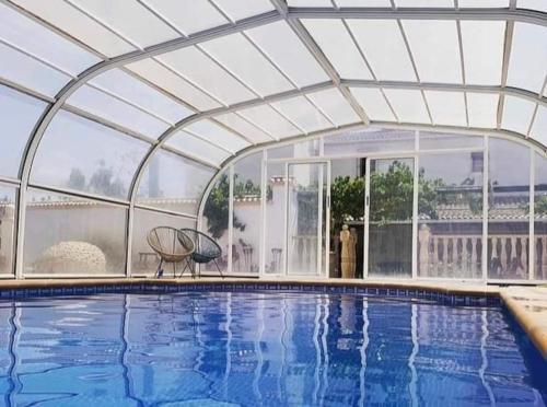 a large swimming pool with a retractable roof at Casa rural Camino de Morazara in Fines
