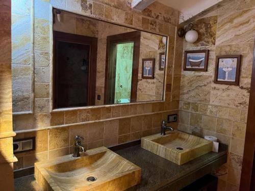 a bathroom with two sinks and a large mirror at Casa rural Camino de Morazara in Fines
