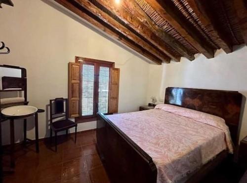 a bedroom with a bed and a table and a window at Casa rural Camino de Morazara in Fines
