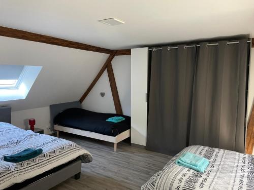 une chambre avec deux lits jumeaux et une fenêtre dans l'établissement Gite chez l'Olivier, à Linthal