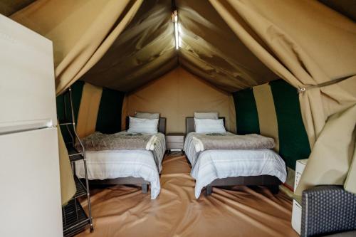 a room with three beds in a tent at Peace Haven @ Windfarm Accommodation in Yzerfontein