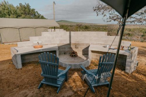 two blue chairs and a table and a fire pit at Peace Haven @ Windfarm Accommodation in Yzerfontein