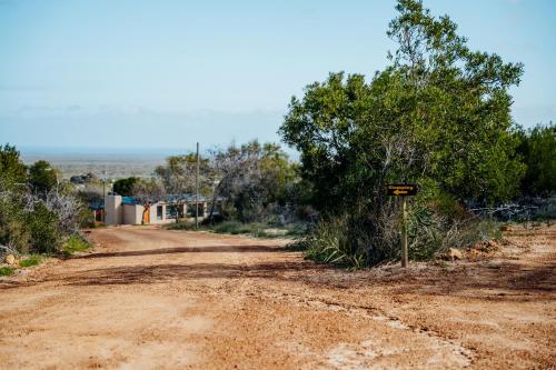 a dirt road with a sign on the side at Peace Haven @ Windfarm Accommodation in Yzerfontein