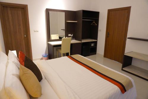 a bedroom with a large bed and a desk at TME Retreats Dhigurah in Dhigurah