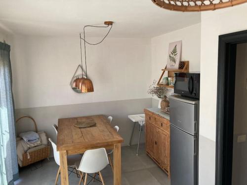 a small kitchen with a table and a refrigerator at Pool House Mencey in El Médano