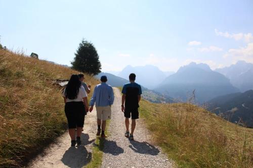 a group of three people walking down a mountain trail at Tabià di Francesca - fienile tra le montagne silenziose in Candide