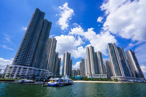 a boat in the water in front of a city at Cozy Beachfront Seaview with 2 CarParks FOC Netflix Access and YouTube Premium 3Beds3Bath 6-11pax by Minshuku in Johor Bahru