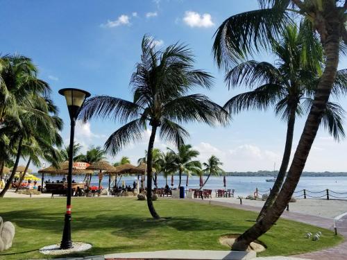 a view of a beach with palm trees and the ocean at Cozy Beachfront Seaview with 2 CarParks FOC Netflix Access and YouTube Premium 3Beds3Bath 6-11pax by Minshuku in Johor Bahru