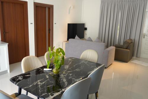 a living room with a dining room table with chairs at TME Retreats Dhigurah in Dhigurah
