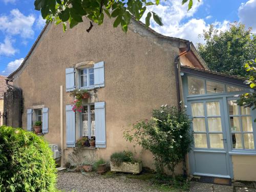 Cette maison ancienne est dotée de portes et de fenêtres bleues. dans l'établissement La Cuverie du Château le Four à Pain, à Corcelles-les-Arts