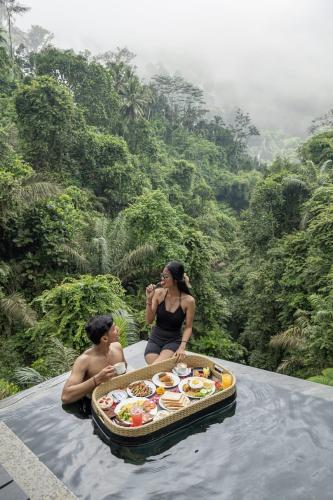 a man and a woman sitting on a boat in the water at Zenubud in Ubud