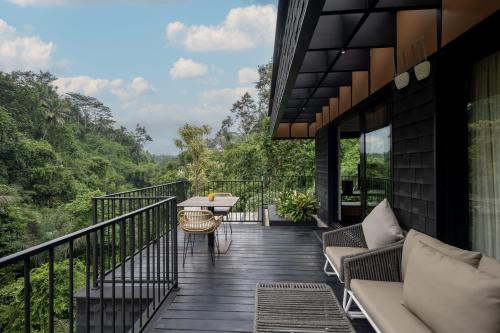 a balcony of a house with a table and chairs at Zenubud in Ubud
