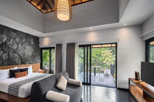 a bedroom with a king sized bed and a television at Zenubud in Ubud