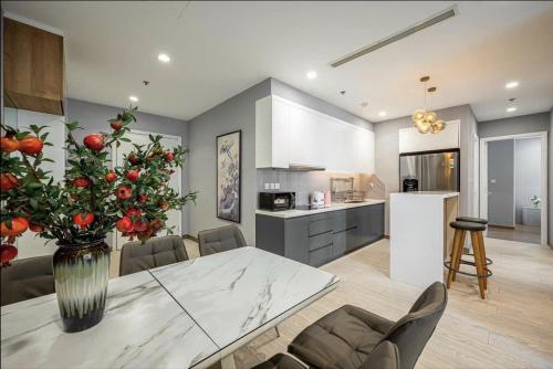 a kitchen and dining room with a table and a vase with fruit at The RIO Ha Do Home City in Ho Chi Minh City