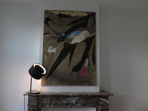 a painting sitting on top of a fireplace with a lamp at La Petite Lili in Dinant