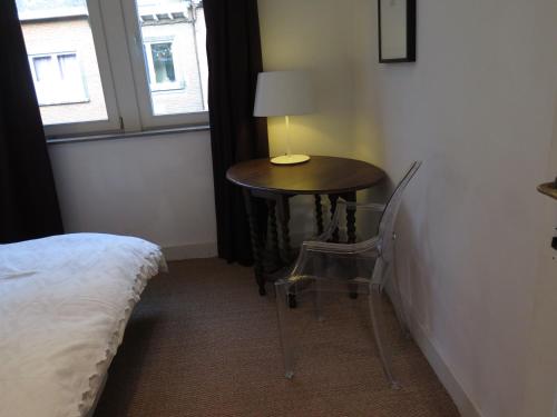 a small table in a room with a lamp on it at La Petite Lili in Dinant