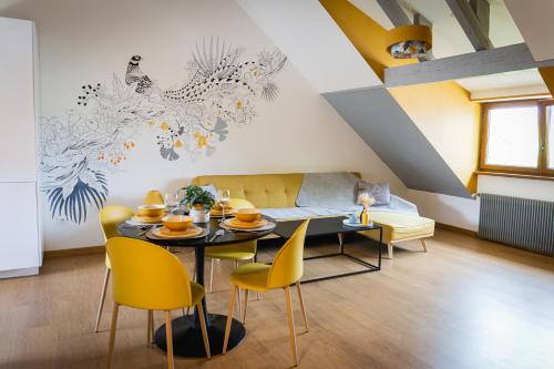 un salon avec une table et des chaises jaunes dans l'établissement Chez Arnaud, à Schiltigheim
