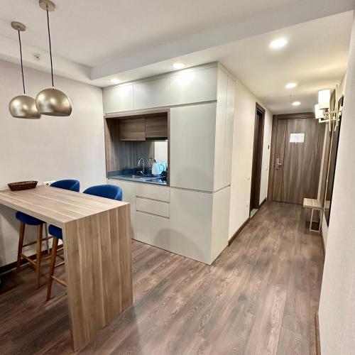 a kitchen and dining room with a table and blue chairs at Business class studio with the Mountain View 115А in Batumi