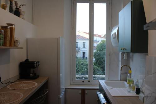 une cuisine avec un évier et une fenêtre dans l'établissement Cocon Spacieux équipé Quartier Prado, à Cannes