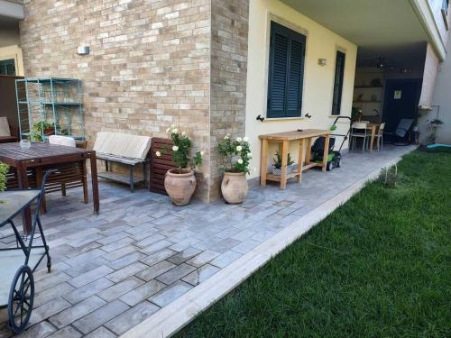 a patio with tables and chairs and a table at Il Giardino di Limoni in Marino