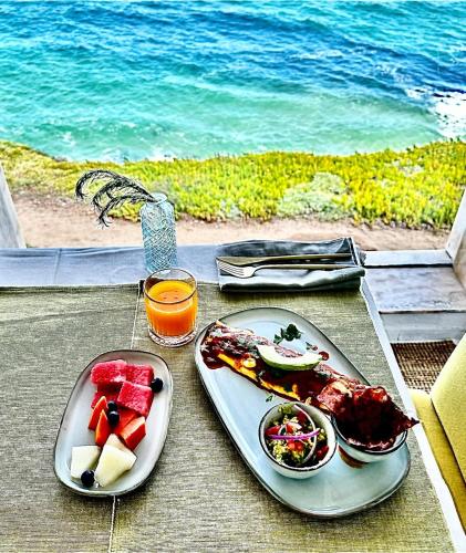 Dos platos de comida en una mesa cerca del océano. en Casal Santa Virginia, en Sintra