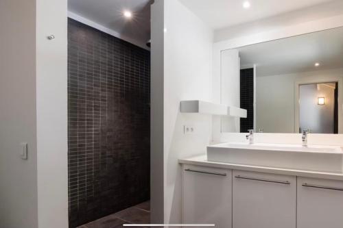 a bathroom with a white sink and a mirror at Casa A Sapa in Bonifacio