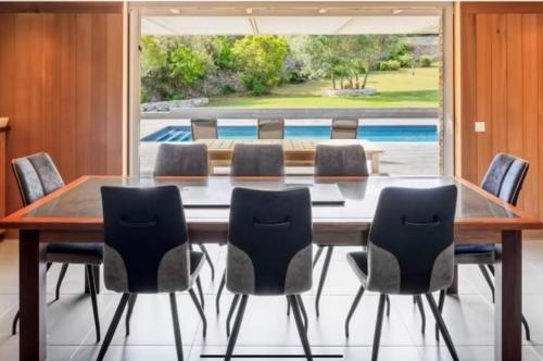une table de salle à manger avec des chaises et une grande fenêtre dans l'établissement Casa A Sapa, à Bonifacio
