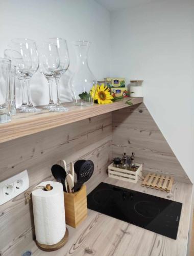 a kitchen with wine glasses on a wooden shelf at Glamping Apiturizem Kr'Bee in Mala Nedelja
