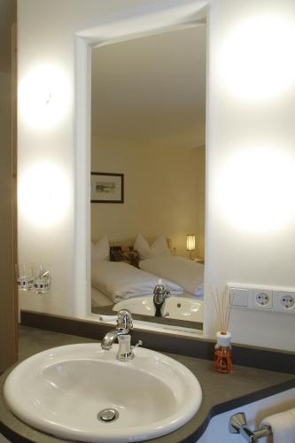 a bathroom with a sink and a large mirror at Dolomit Boutique Hotel in La Villa