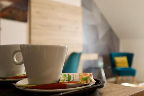 a cup on a table with a plate of food at Christina Residence in Budapest
