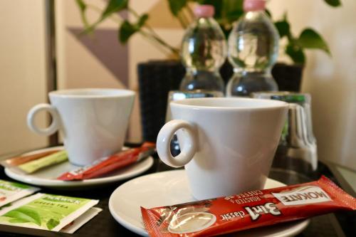two cups and a bag of chips on a table at Christina Residence in Budapest