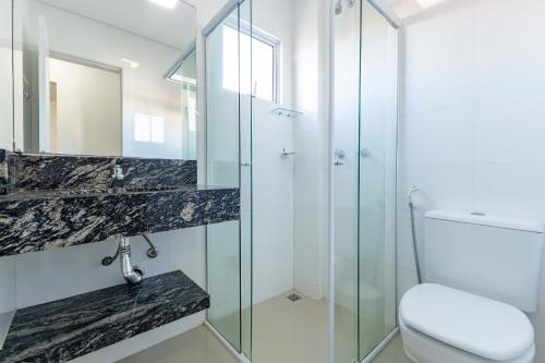 Un baño con ducha de cristal y un inodoro. en Excelente ubicación a 200m de la playa de Bombinhas, en Bombinhas