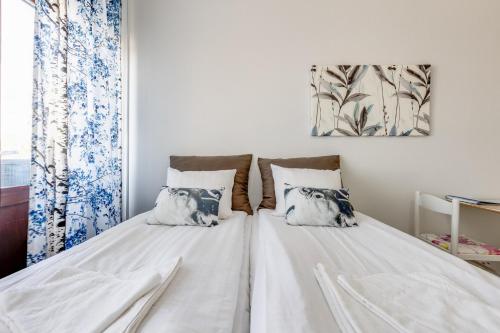 a white bed with two pillows on it in a room at Santa's Holiday Homes in Rovaniemi