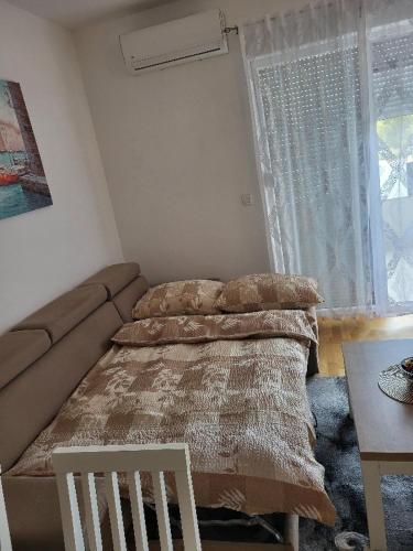 a bedroom with a bed and a couch and a table at Apartman Janja in Čapljina