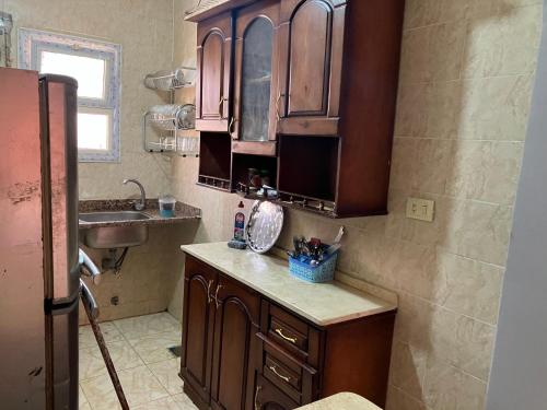 a kitchen with wooden cabinets and a sink at Mina resort ras sudr in Makman