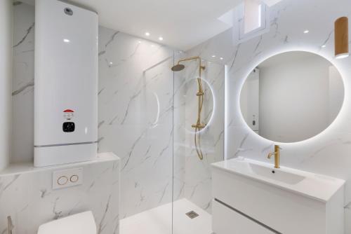 une salle de bain blanche avec un lavabo et un miroir dans l'établissement Casa Josa - Palm Beach, à Cannes