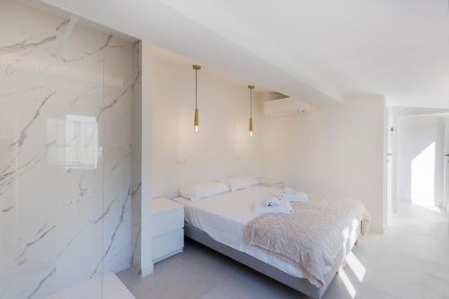 - une chambre blanche avec un lit et des murs blancs dans l'établissement Casa Josa - Palm Beach, à Cannes