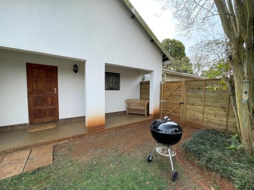 a barbecue grill in the yard of a house at The Stables, Central Garden Cottage in Howick in Howick