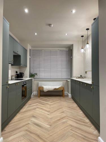 a kitchen with gray cabinets and a bench in it at Hidden Gem Whitstable in Whitstable