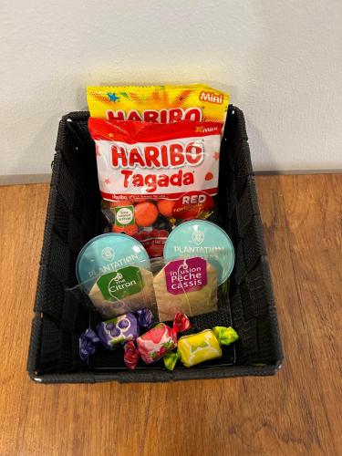 un panier rempli de collations et de bonbons sur une table dans l'établissement Le Calme en plein centre ville de BELFORT, à Belfort