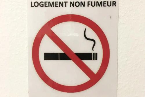 un panneau interdisant de fumer avec une cigarette. dans l'établissement Le Calme en plein centre ville de BELFORT, à Belfort