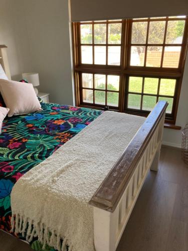 a bedroom with a bed and a large window at Captains Cottage - Pet Friendly Breakfast Included in Goolwa