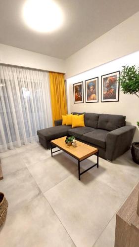 a living room with a couch and a coffee table at Epsilon - Premier Apartment & Easy Parking by Optimum Link in Katerini